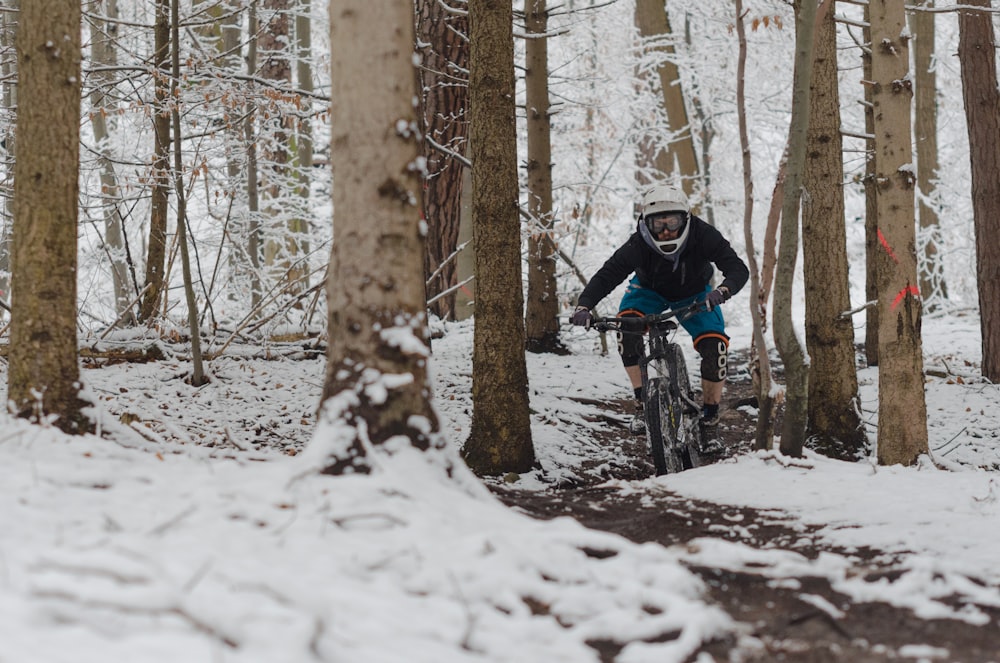 Homem andando de bicicleta em campo coberto de neve