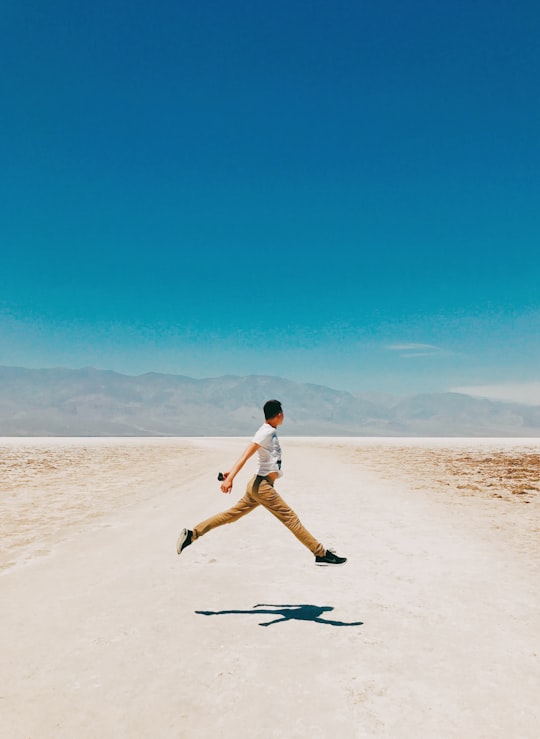 man jumped on ground in Badwater Basin United States