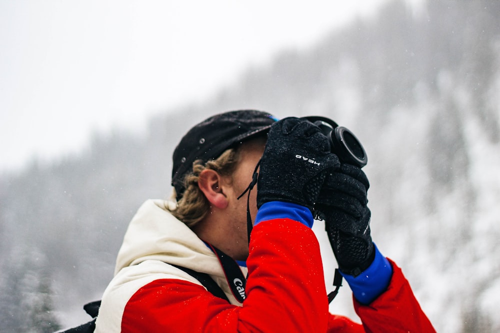 pessoa segurando a câmera no campo de neve