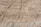 Natural stone surface with visible layers and veins, showcasing a blend of earthy colors and rough textures.
