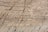 Natural stone surface with visible layers and veins, showcasing a blend of earthy colors and rough textures.