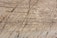 Natural stone surface with visible layers and veins, showcasing a blend of earthy colors and rough textures.