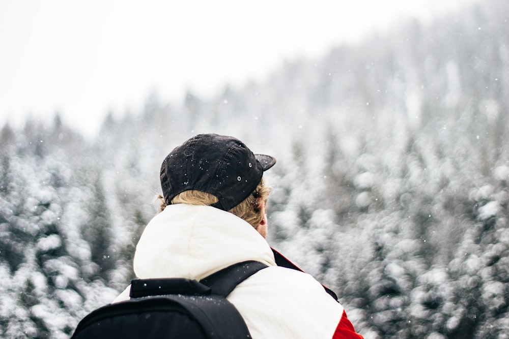 person wearing black cap and backpack bokeh photography