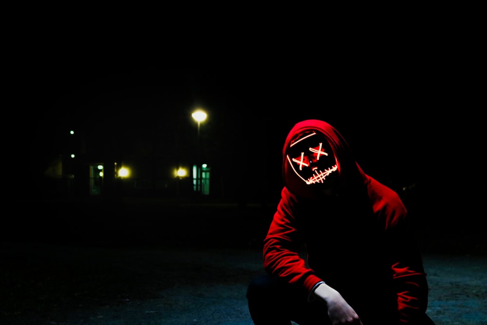 man squatting during nighttime