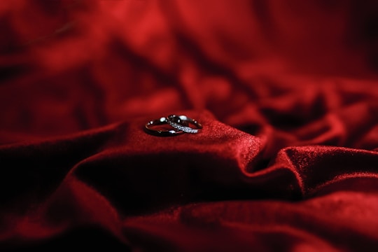 A pair of elegant wedding bands resting on a velvet cushion inside the store.
