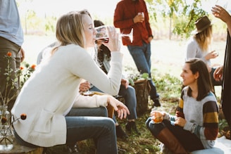 woman sitting near people while drinking