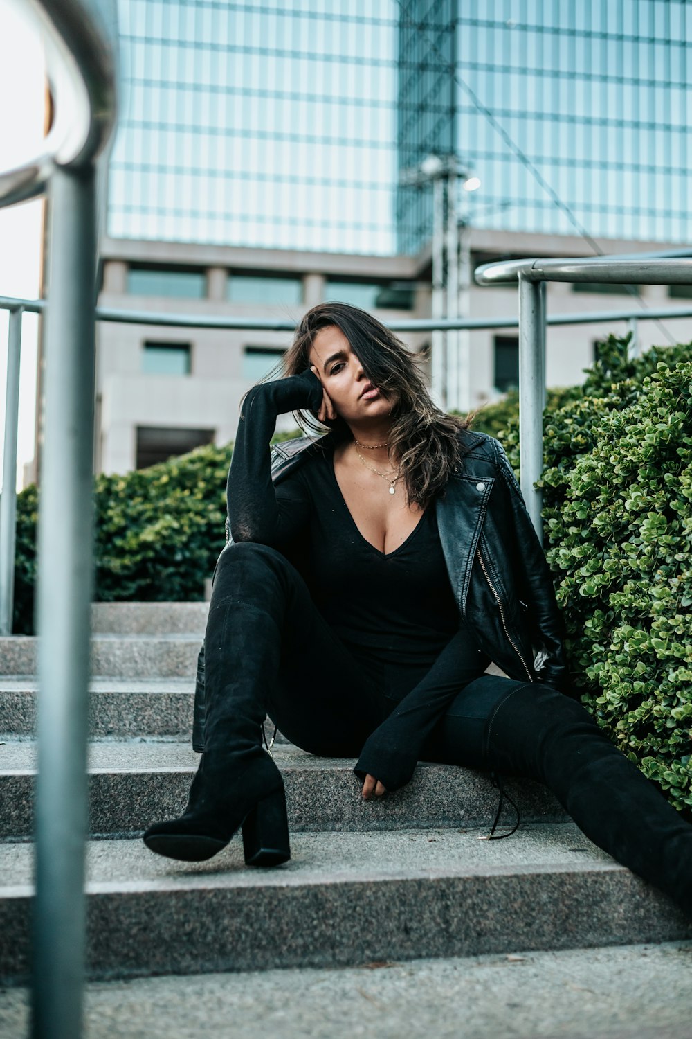 woman sitting on stair beside plants