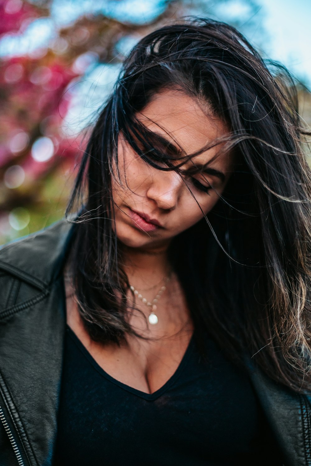 woman wearing black leather jacket and black V-neck top