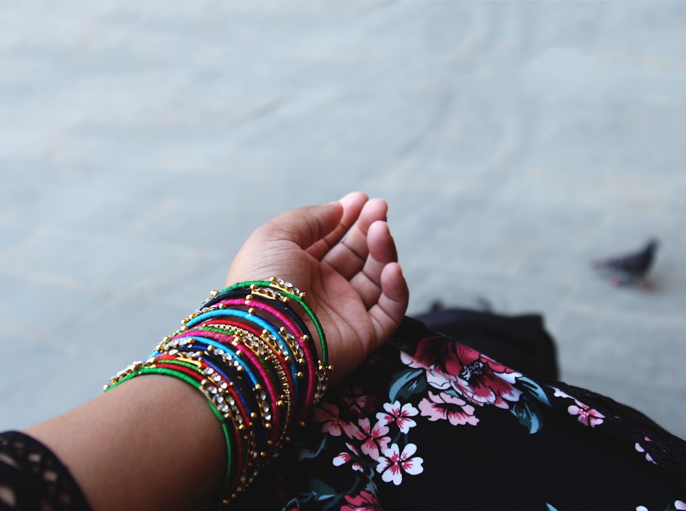 person showing assorted-color thread bangles