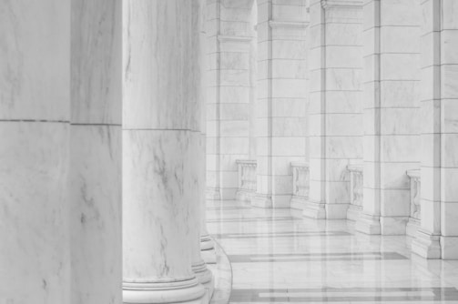 minimalist photography of hallway between columns