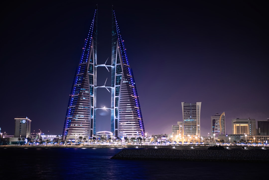 triangular-shape tower near body of water, Bahrain at Night