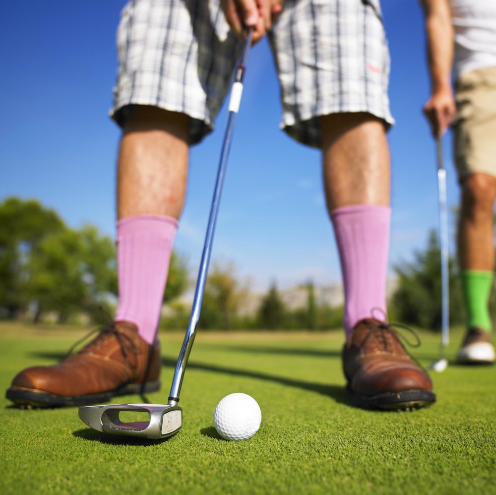 foto ad angolo basso di un uomo che gioca a golf scattata durante il giorno