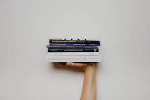 person holding pile of books