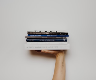 person holding pile of books