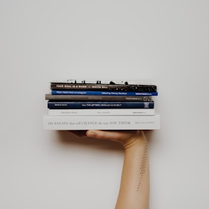 person holding pile of books