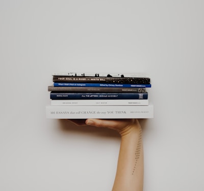person holding pile of books