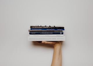 person holding pile of books