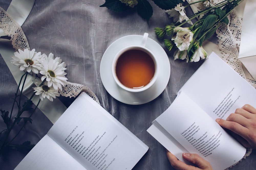 Weiße Tasse mit Untertasse in der Nähe von Bok