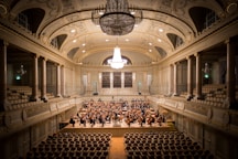 music group performing on stage with empty audience seats