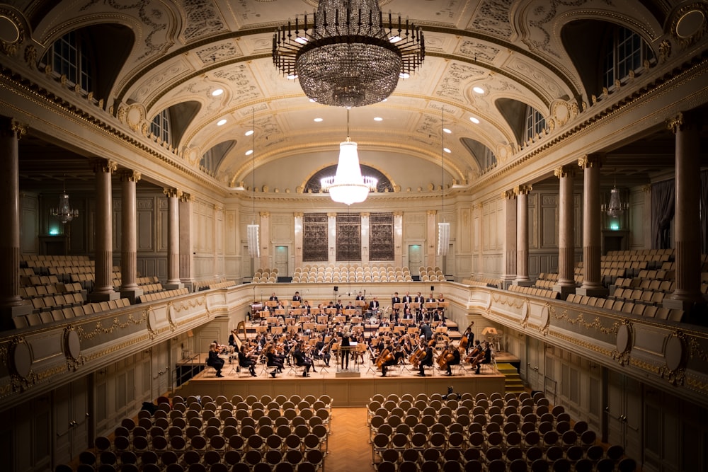 music group performing on stage with empty audience seats