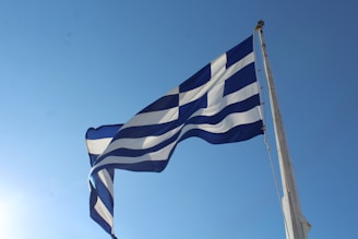 A vibrant Polish flag waving proudly against a clear blue sky, symbolizing national pride and unity.