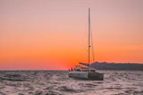 Elegant sailboat cutting through gentle waves at sunset