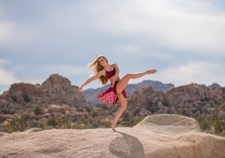 woman dancing on brown hill during daytime