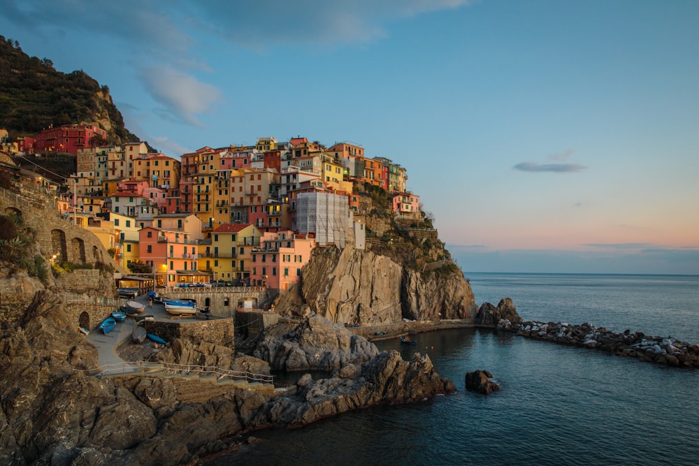 edifici vicino alla scogliera sotto il cielo blu e bianco durante la fotografia diurna