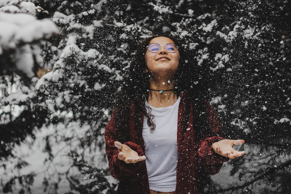 Mujer con camisa blanca tocando la nieve