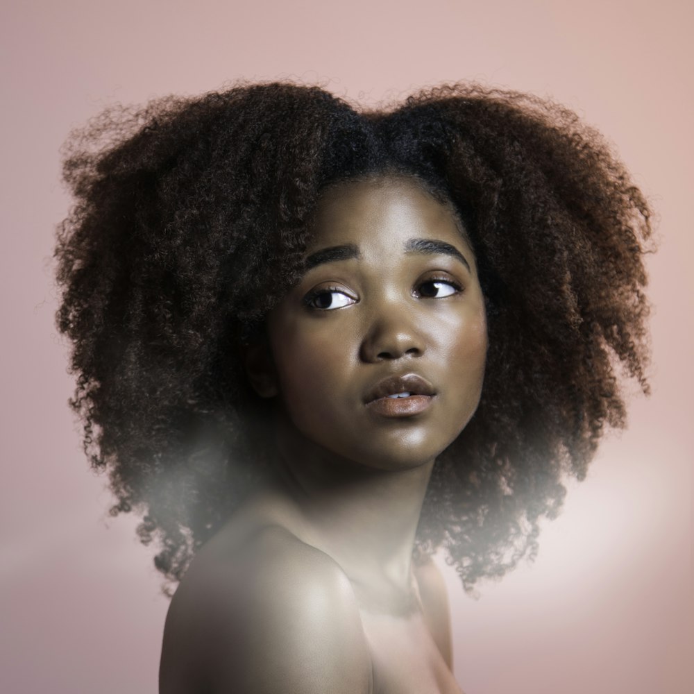 a woman with an afro is looking at the camera