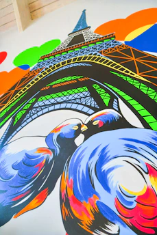 Poppy and Penny happily coloring by the Eiffel Tower on a sunny day.