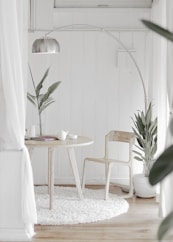 white steel chair in front round table on white rug