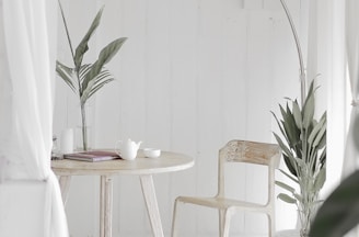 white steel chair in front round table on white rug