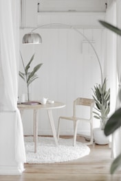 white steel chair in front round table on white rug