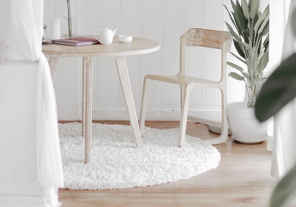 white steel chair in front round table on white rug