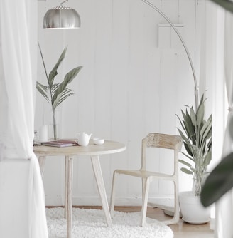 white steel chair in front round table on white rug