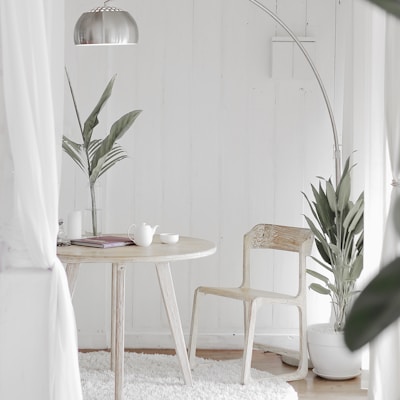 white steel chair in front round table on white rug