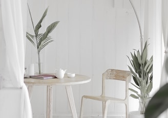 white steel chair in front round table on white rug