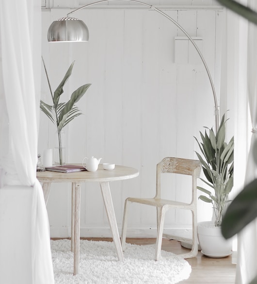 white steel chair in front round table on white rug