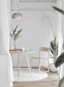 white steel chair in front round table on white rug