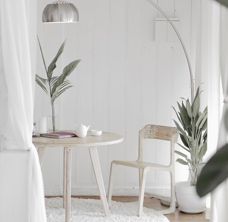 white steel chair in front round table on white rug