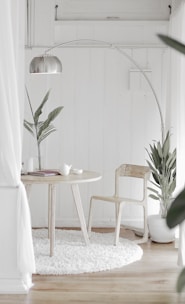 white steel chair in front round table on white rug