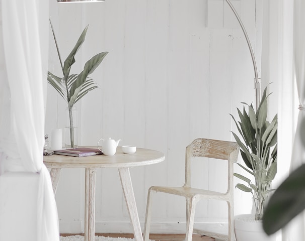 white steel chair in front round table on white rug