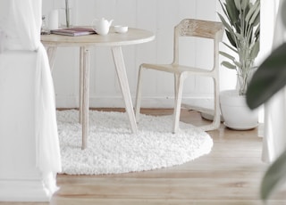 white steel chair in front round table on white rug