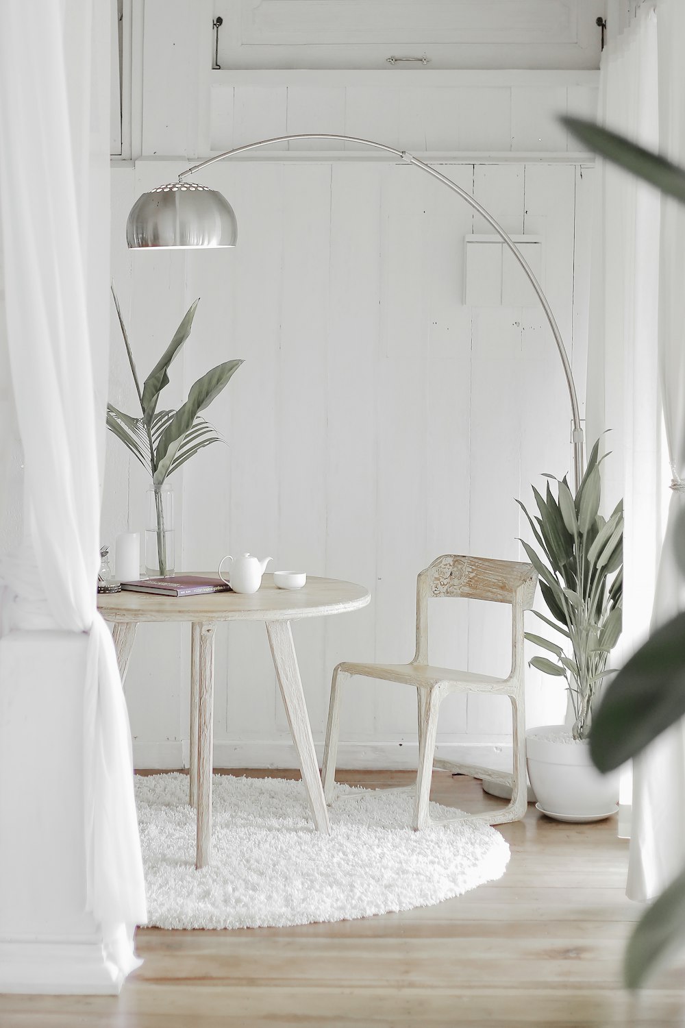 white steel chair in front round table on white rug