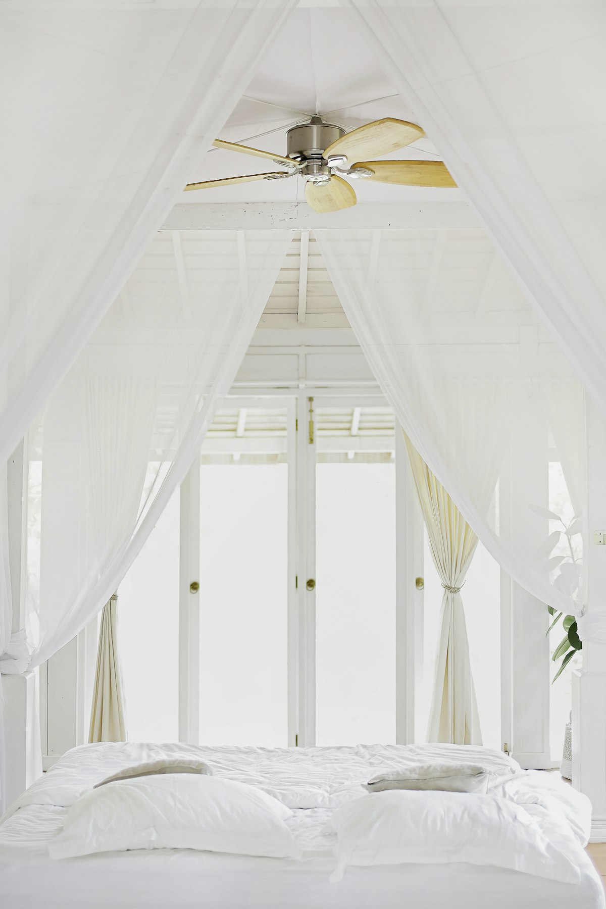 Sheer white curtains moving in soft light by a window
