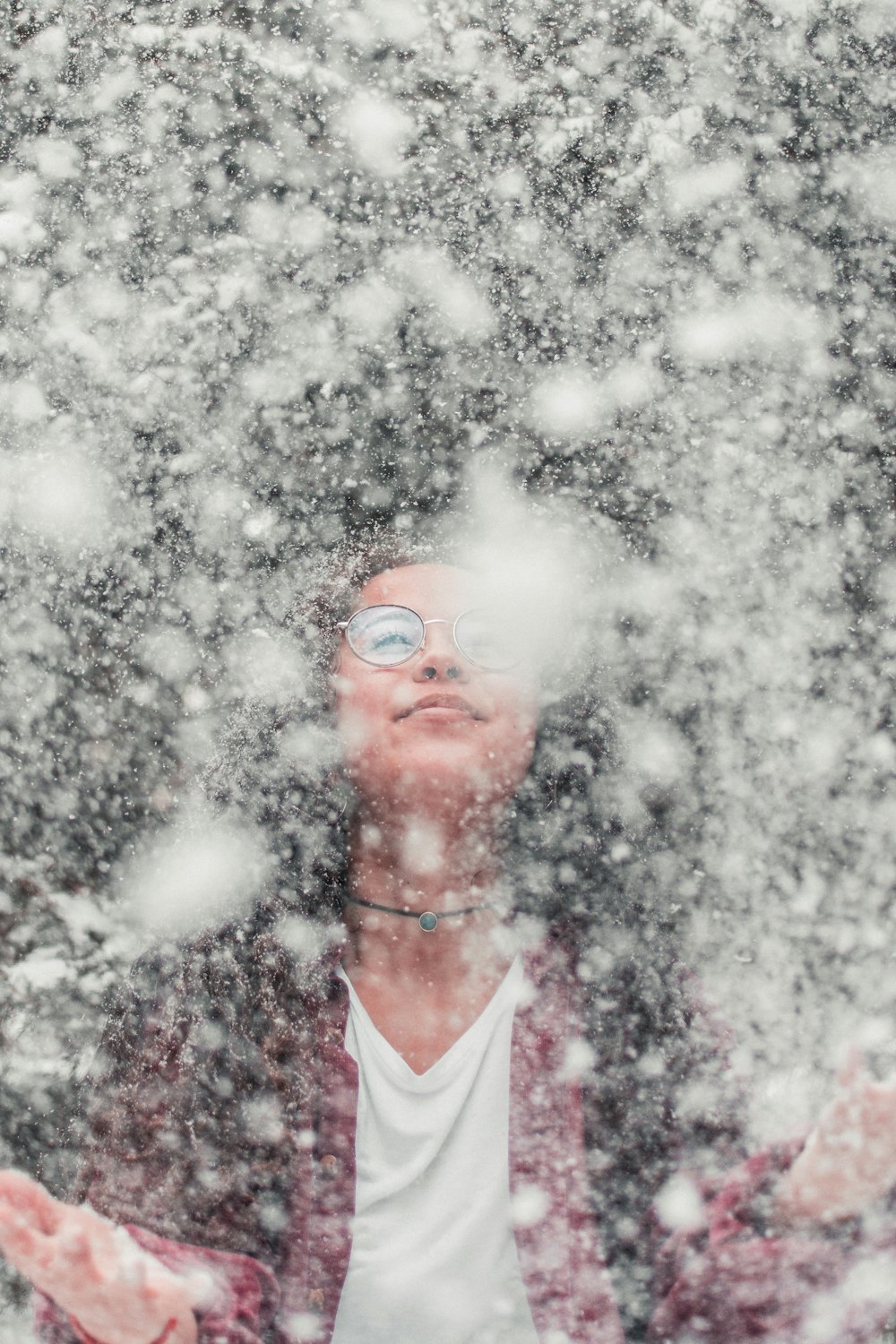 Frau versucht, den fallenden Schnee aufzufangen