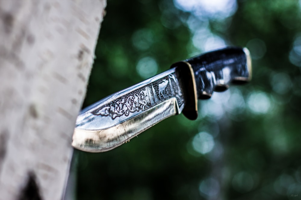 gray metal knife on tree log