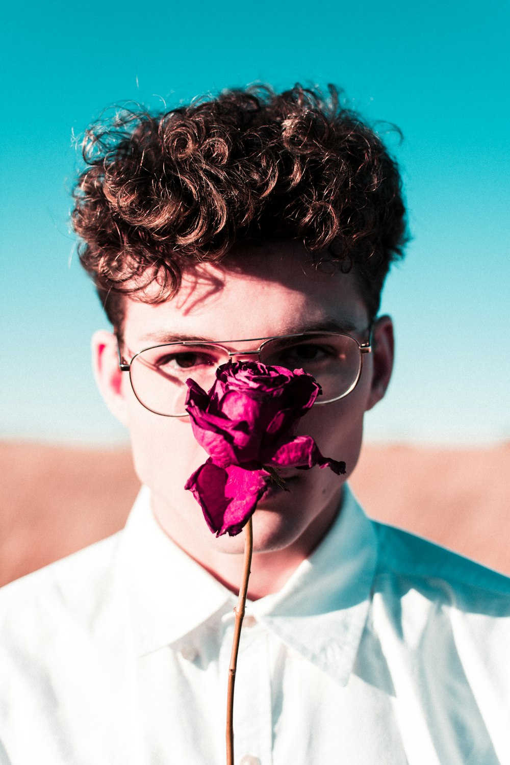 man with rose in front of face