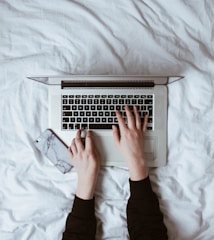 A person typing an email inquiry on a smartphone.